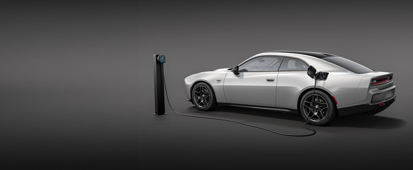 Un Charger Daytona BEV 2026 de última generación de dos puertas con el cable de carga de una estación de carga de nivel 2026 enchufado al puerto de carga del vehículo.