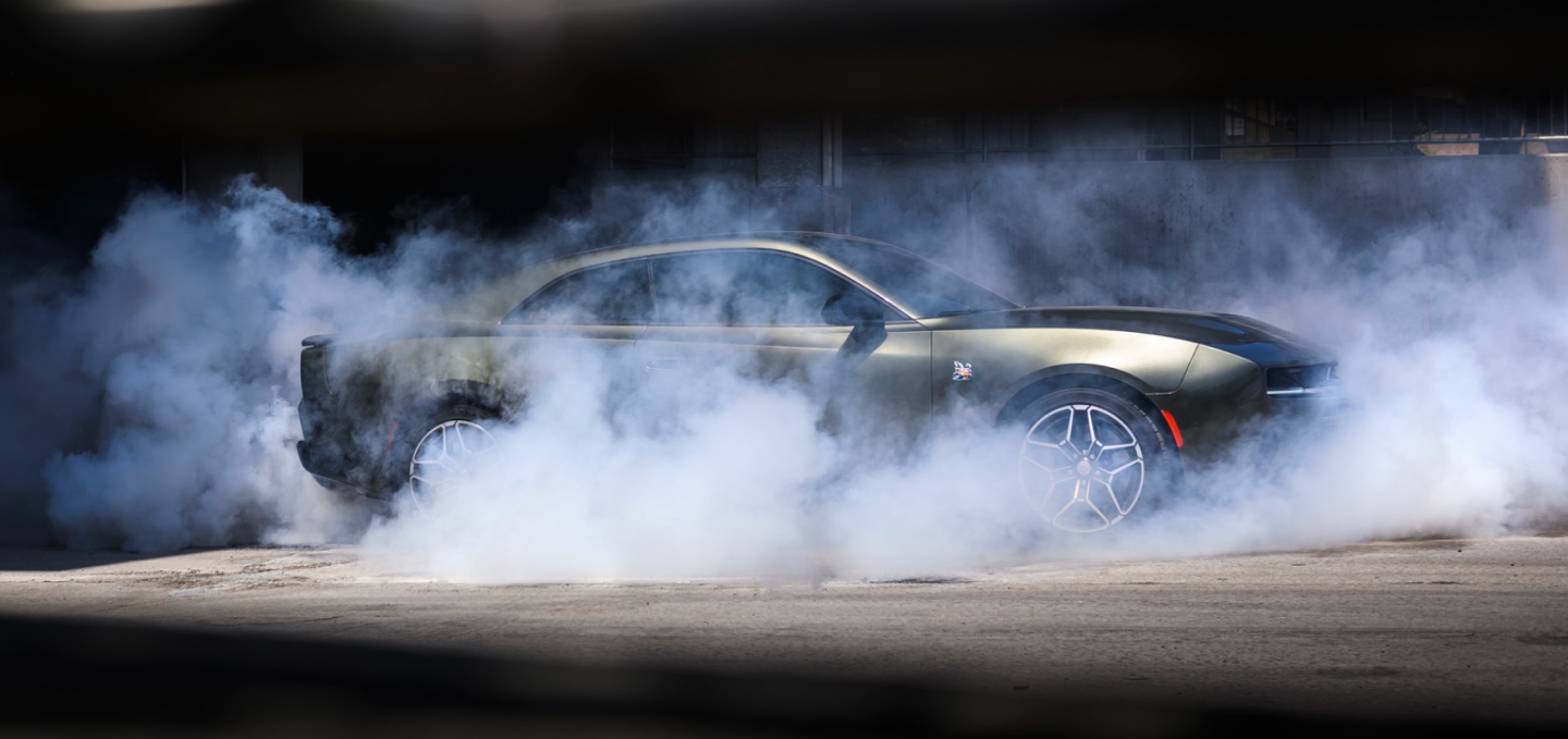 Un Dodge Charger Scat Pack 2027 plateado de perfil, con humo alrededor del coche.