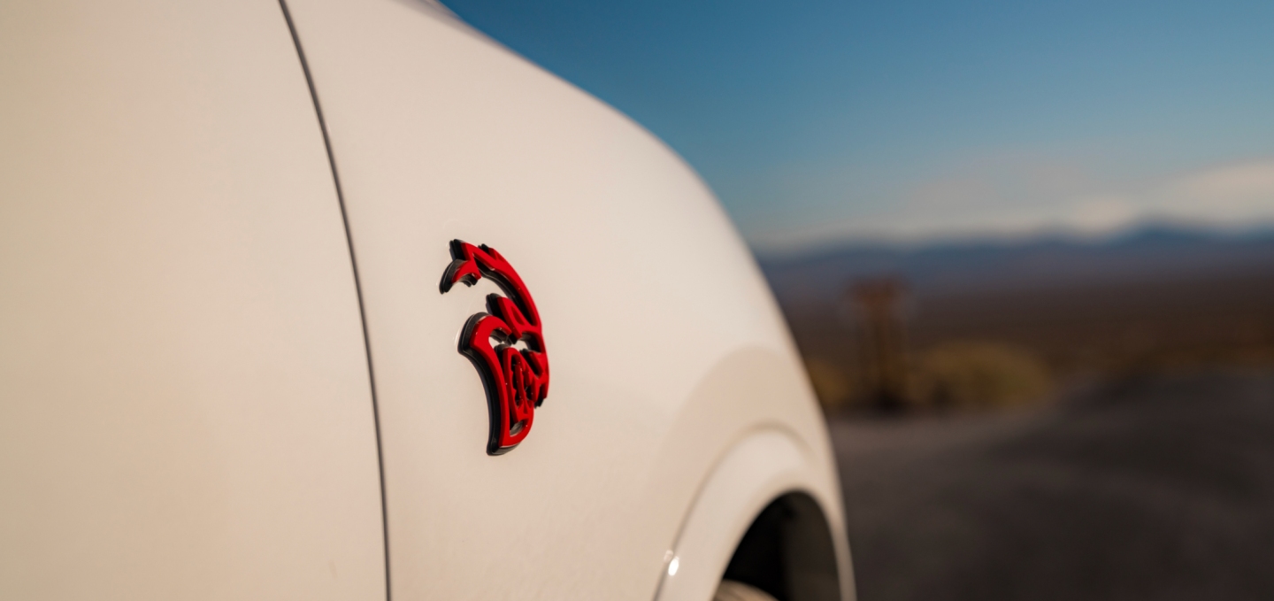 El emblema Hellcat rojo del lado del pasajero de un Dodge Durango SRT Hellcat Jailbreak 2027 beige.