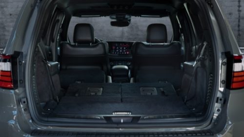 La zona de carga de un Dodge Durango GT Hemi V8 2027 con los asientos de la trcera fila plegados. Toma a través de la puerta trasera levadiza abierta.