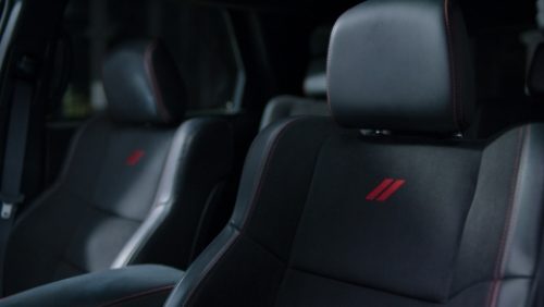 Los asientos delanteros tapizados en cuero negro y costuras rojas de un Dodge Durango R/T 392 2027.
