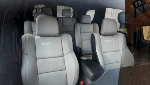 Los asientos tapizados en cuero gris en las tres filas del Dodge Durango SRT Hellcat Jailbreak 2027, con el logo de SRT Hellcat grabado en relieve en los asientos delanteros.