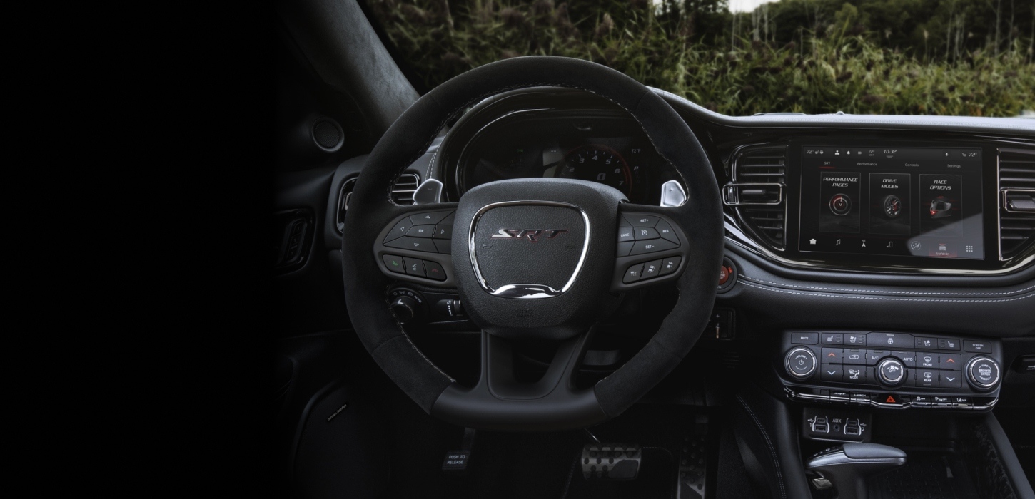 El volante, la pantalla digital en el panel de instrumentos, la pantalla táctil Uconnect y los controles de temperatura en el Dodge Durango SRT Hellcat Jailbreak 2027​​​​​​​.