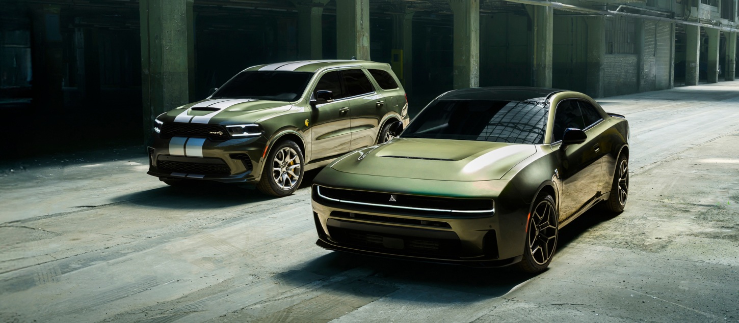 Un Dodge Durango SRT Hellcat Jailbreak 2026 verde con dos franjas centrales blancas y un Dodge Charger Scat Pack Plus 2026 verde estacionados uno al lado del otro.